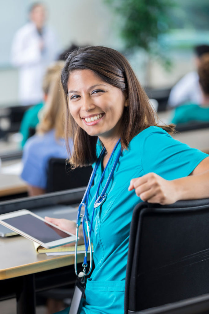 Lady wearing scrubs in a classroom